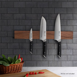 
                    
                      Walnut magnetic knife bar mounted on gray brick wall holding three knives with black handles above a cutting board and basket
                    
                  