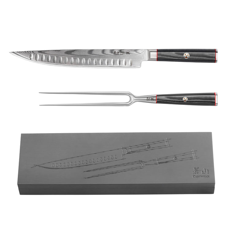 Carving knife and fork with black handles and Damascus steel blades, displayed above a matching ash wood storage box.