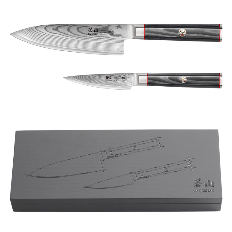 Two Damascus steel knives with dark handles and red accents, displayed above a gray box featuring etched knife illustrations.