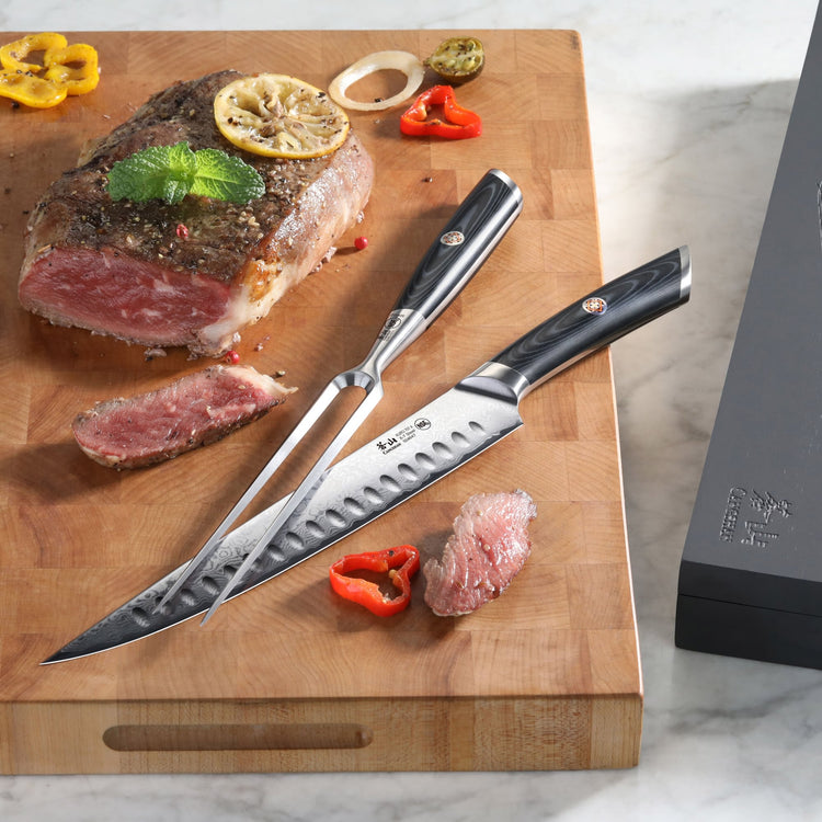 Two high-carbon Damascus steel carving knives with black handles on a wooden cutting board with sliced roast beef and garnish