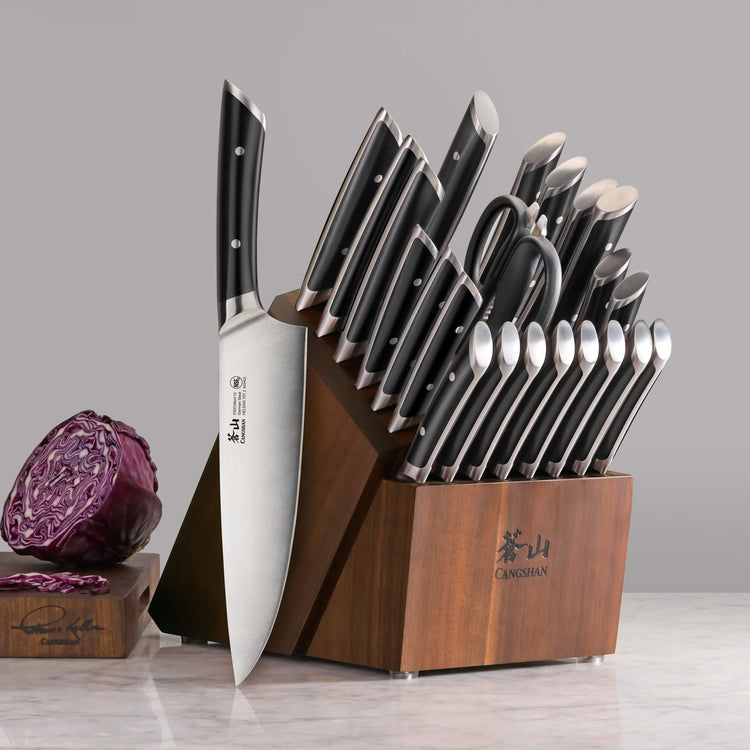 23-piece knife block set with black-handled knives and acacia wood block on marble surface.