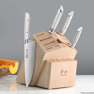 
                    
                      Maple knife block with 16 slots, holding four knives with white handles, on a marble surface.
                    
                  