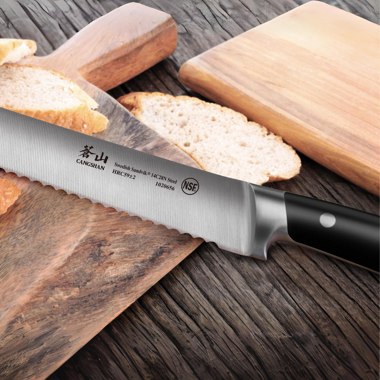 TS Series 8-inch bread knife with serrated forged Swedish steel blade and black handle resting on wooden cutting board with s