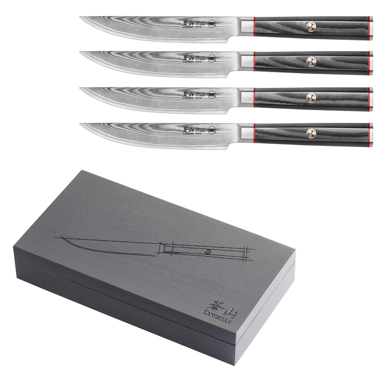 Four steak knives with patterned Damascus steel blades and dark handles, displayed above a closed dark wood storage box.