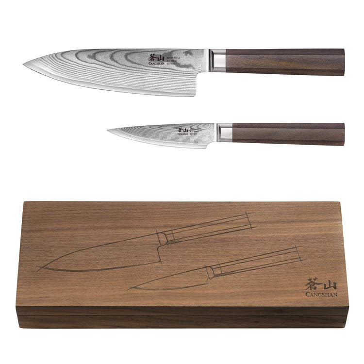 Two Damascus steel knives with wooden handles displayed above a walnut wood box engraved with knife outlines.