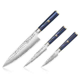 
                    
                      Three kitchen knives with hammered Damascus steel blades and blue handles with gold accents, arranged side by side.
                    
                  