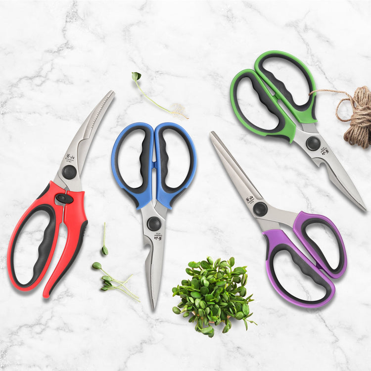 Four heavy-duty kitchen shears with colorful handles in red, blue, green, and purple on a marble surface with herbs and twine