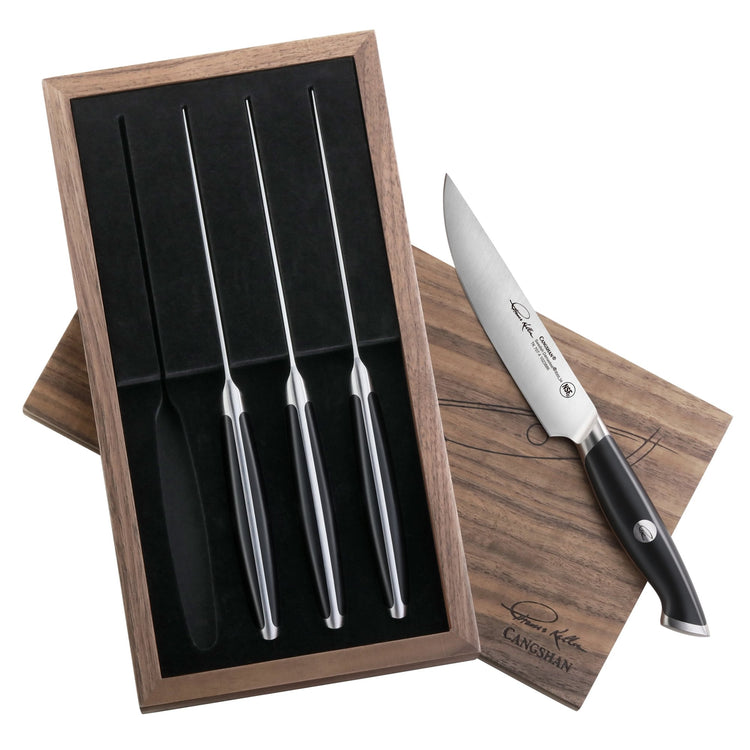 Four black-handled steak knives in a walnut storage box with one knife displayed outside the box.