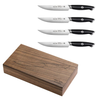 
                    
                      Four black-handled steak knives with stainless steel blades and a walnut storage box with knife illustration and signature.
                    
                  