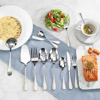 
                    
                      Set of stainless steel flatware with matte finish handles displayed on a blue cloth, alongside soup, salad, and salmon dishes
                    
                  