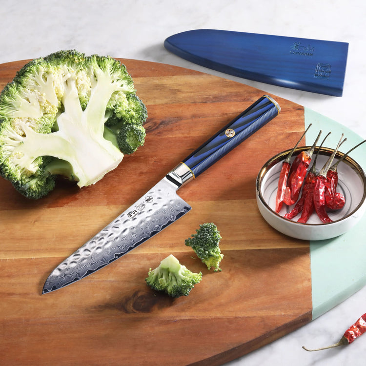 KITA Series 5.5-inch prep utility knife with blue handle and Damascus steel blade on wooden board with broccoli and red chili