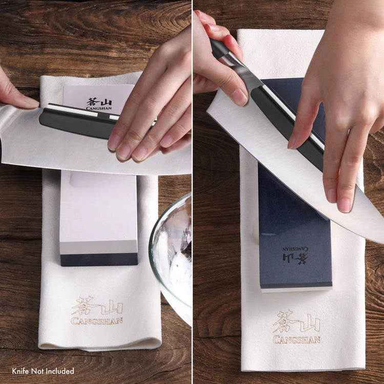 Hands sharpening a knife on a dual-sided whetstone with a cloth underneath on a wooden surface.
