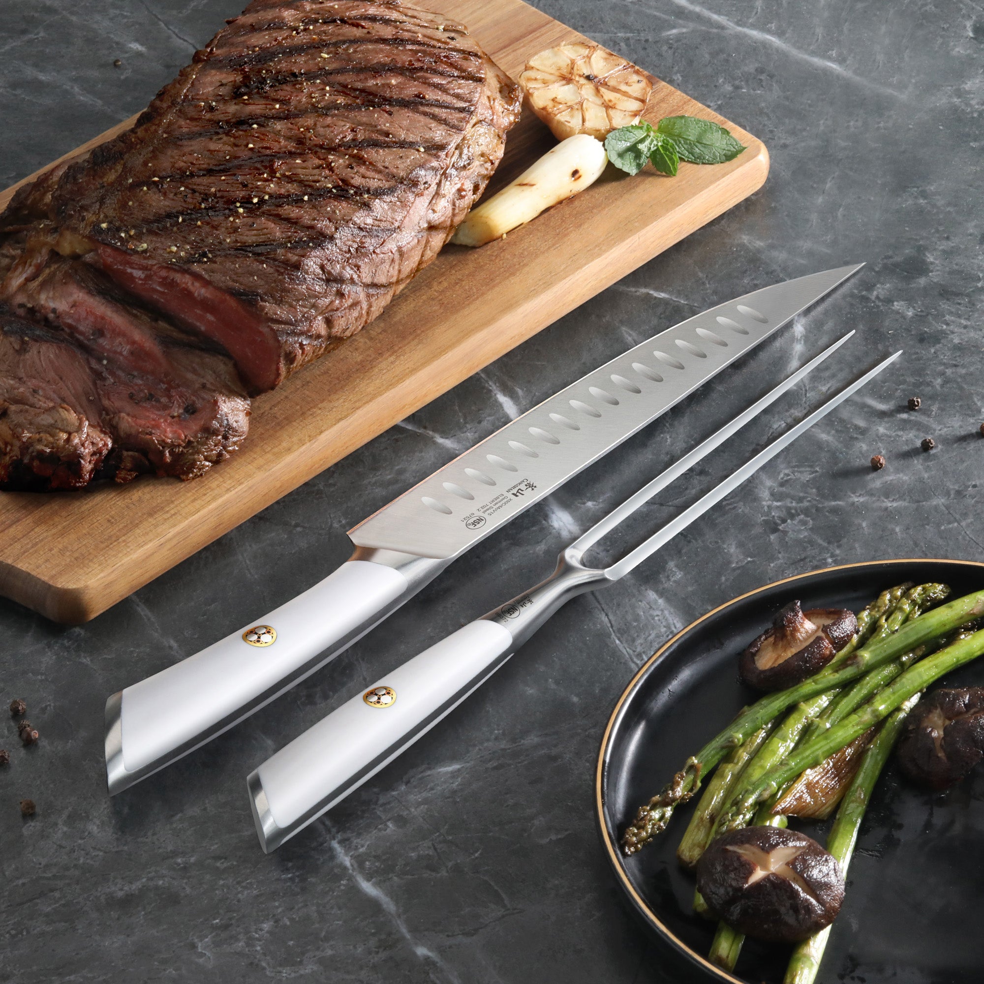 Carving knife and fork set with silver handles beside sliced roast beef on a wooden board and a plate of asparagus and mushro