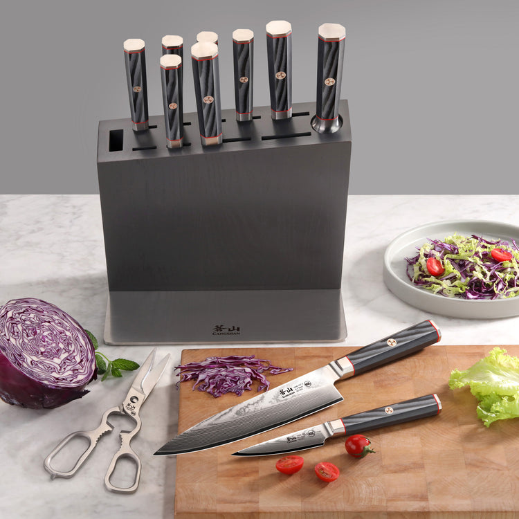 Knife block set with eight knives featuring black handles and copper accents, two knives on cutting boards with chopped veget