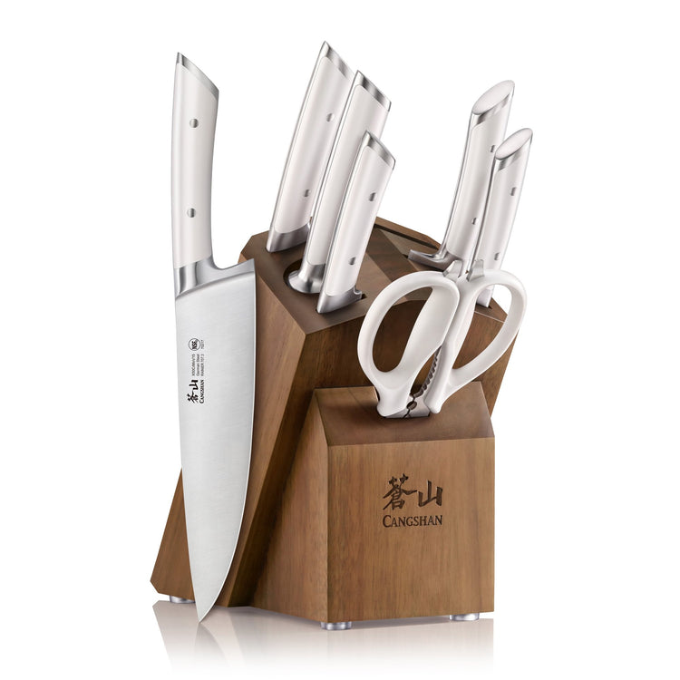 Wooden knife block holding six stainless steel knives and a pair of kitchen scissors.