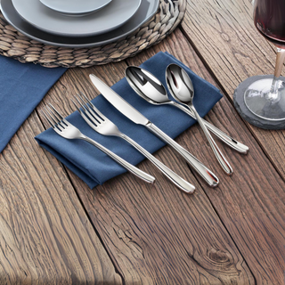 
                    
                      Five pieces of polished stainless steel flatware—salad fork, dinner fork, knife, tablespoon, and teaspoon—rest on a blue napk
                    
                  