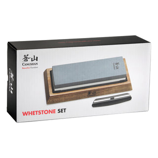 
                    
                      Dual-sided whetstone on wooden base with black knife sharpening guide beside it in product packaging box.
                    
                  