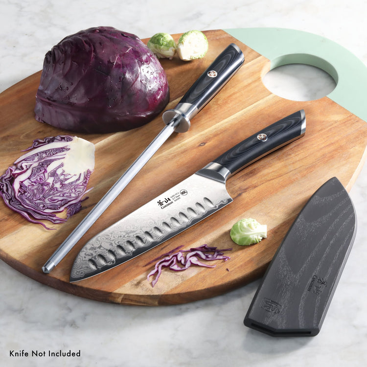 9-inch honing steel with black handle and a knife with black handle on a wooden cutting board with cabbage and Brussels sprou