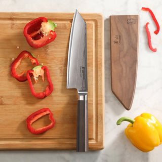 
                    
                      MAYA Series 7-Inch Kiritsuke Knife X-7 Damascus Steel on a wooden cutting board beside its wooden sheath.
                    
                  