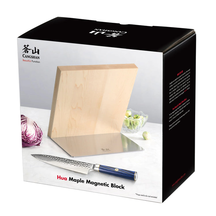 Maple wood magnetic knife block with a stainless steel base, displayed with a chef's knife and vegetables.