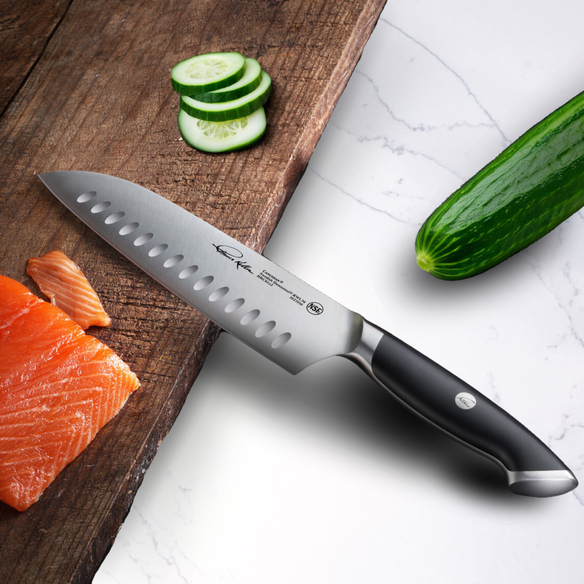 TKSC 7-inch Santoku knife with black handle slicing cucumber on wooden cutting board next to salmon fillet and whole cucumber