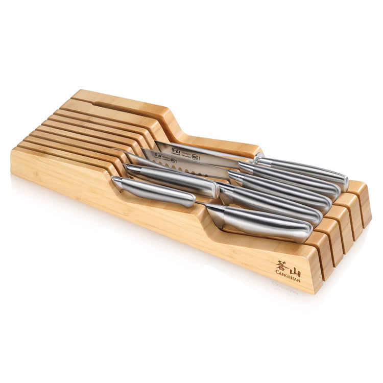 Eight stainless steel knives neatly arranged in a bamboo in-drawer knife organizer.