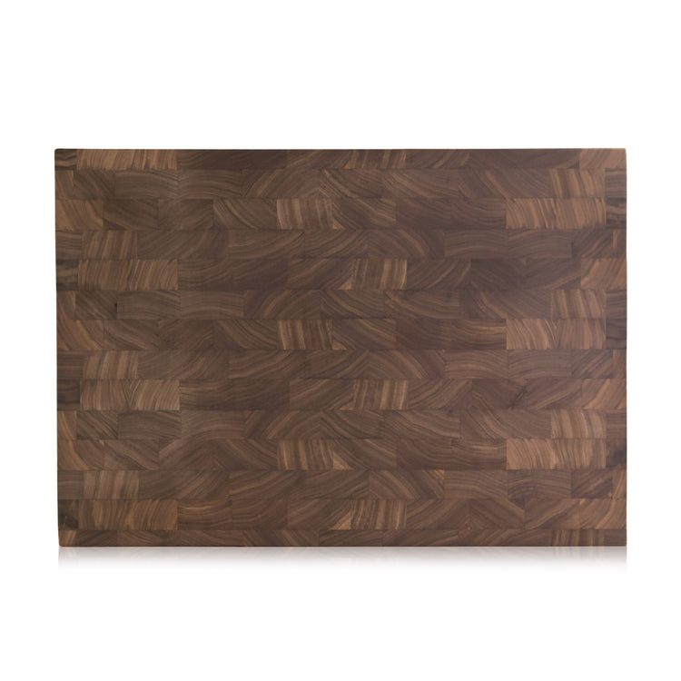 Rectangular walnut end-grain cutting board with a smooth, patterned wood surface and 1.5-inch thickness.