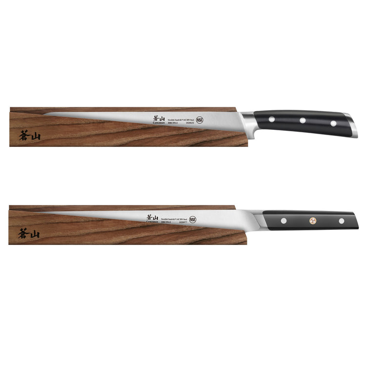 Two long, slender kitchen knives with black handles resting on solid ash wood magnetic sheaths.