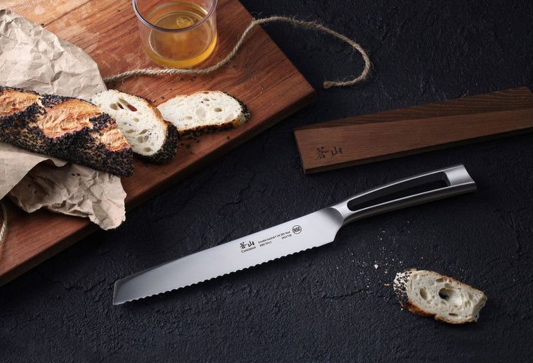 TN1 Series 8-inch serrated bread knife with black handle, ash wood sheath, sliced bread, and honey on wooden board.