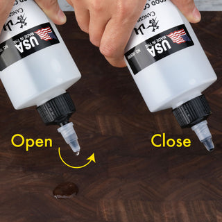 
                    
                      Hands demonstrating how to open and close a white mineral oil bottle with a twist cap dispensing oil on a wooden surface.
                    
                  