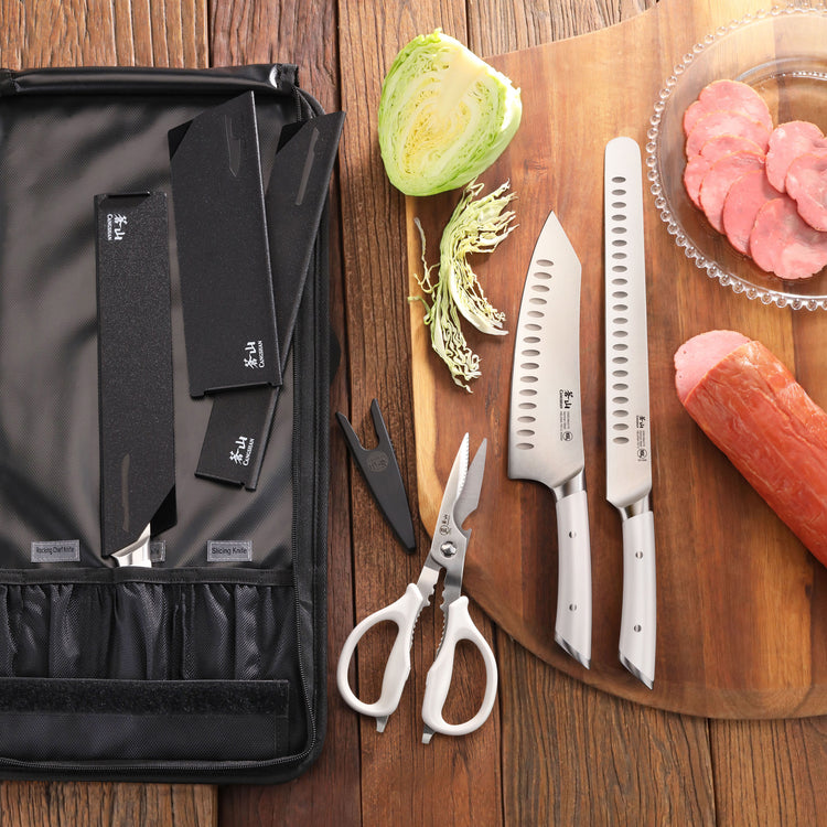 Nine-piece knife set with black handles and blades, kitchen scissors, and a black carrying case on a wooden surface.