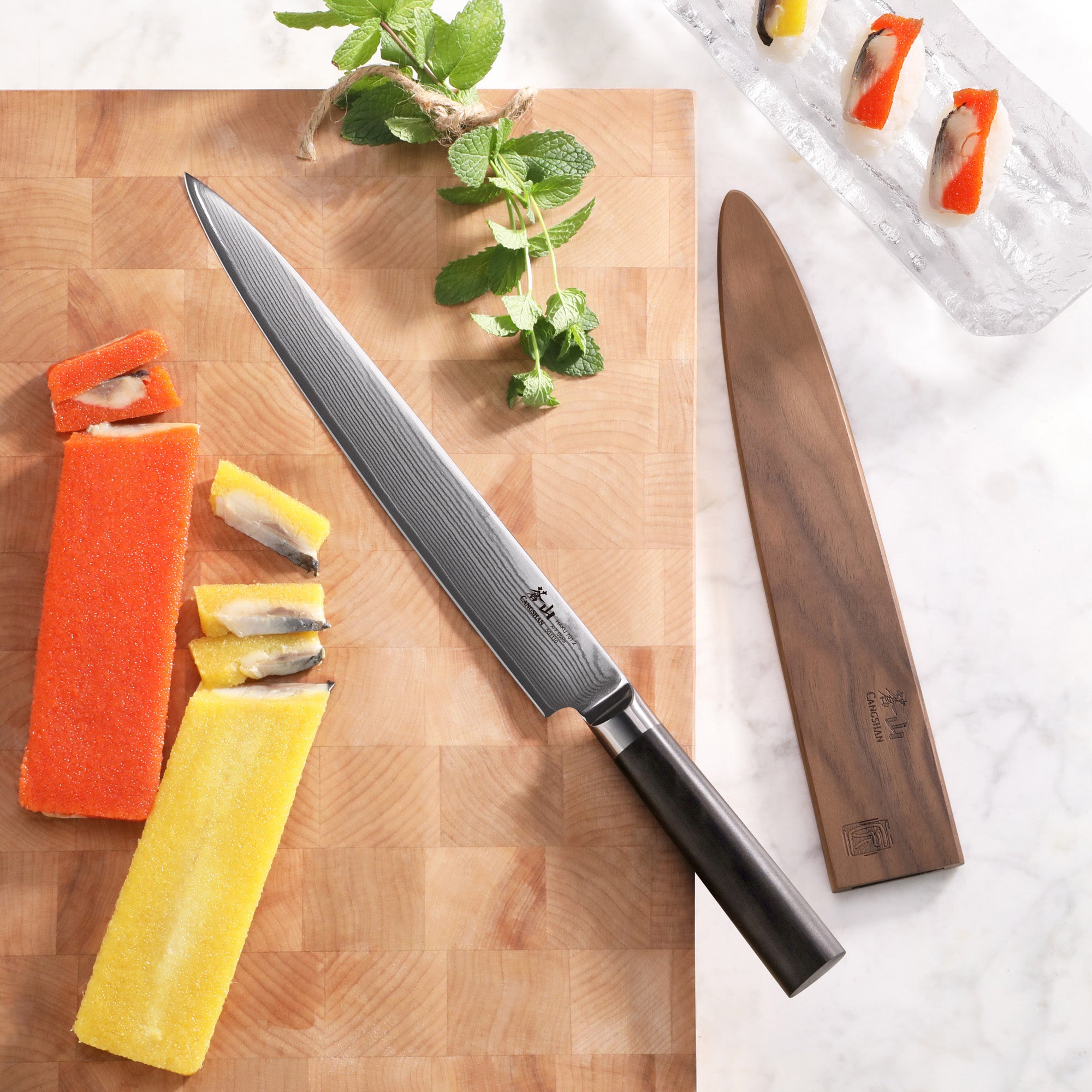 10-inch sashimi knife with Damascus steel blade and African Blackwood handle on wooden cutting board with sushi pieces and sh