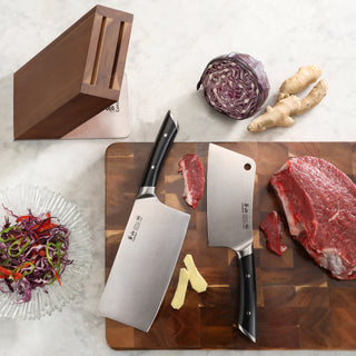 
                    
                      Two cleaver knives with black handles on a wooden cutting board with raw beef, ginger, and red cabbage, next to an empty acac
                    
                  