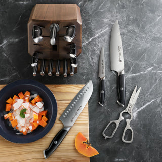 
                    
                      TKSC 17-piece knife block set featuring a wooden knife block, steel kitchen knives, and shears on a marble counter.
                    
                  