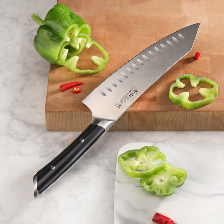 8-inch chef's knife with black handle on wooden cutting board next to sliced green bell pepper and red chili pieces.