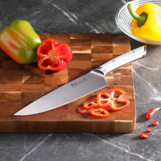 
                    
                      8-inch chef's knife on wooden cutting board with sliced red bell pepper and whole green and yellow peppers nearby
                    
                  
