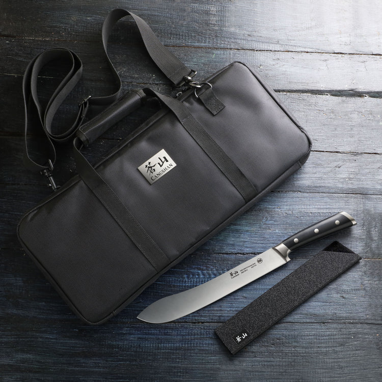 Black cut-resistant nylon knife bag with shoulder strap, alongside a chef's knife and black blade cover on a wooden surface.
