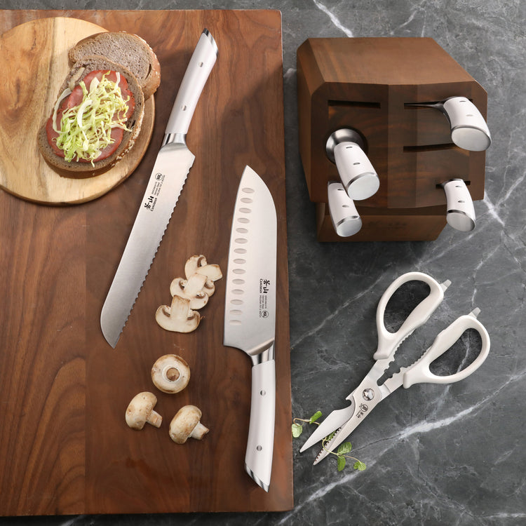 8-piece knife block set with two knives, kitchen shears, and acacia wood block on gray countertop.