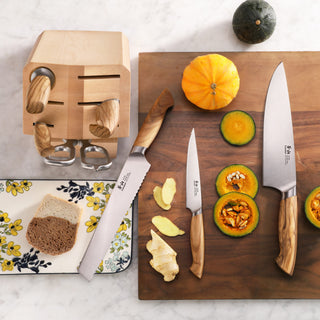 
                    
                      Wood-handled knives with a wooden block, sliced pumpkin, and ginger on a wooden cutting board.
                    
                  