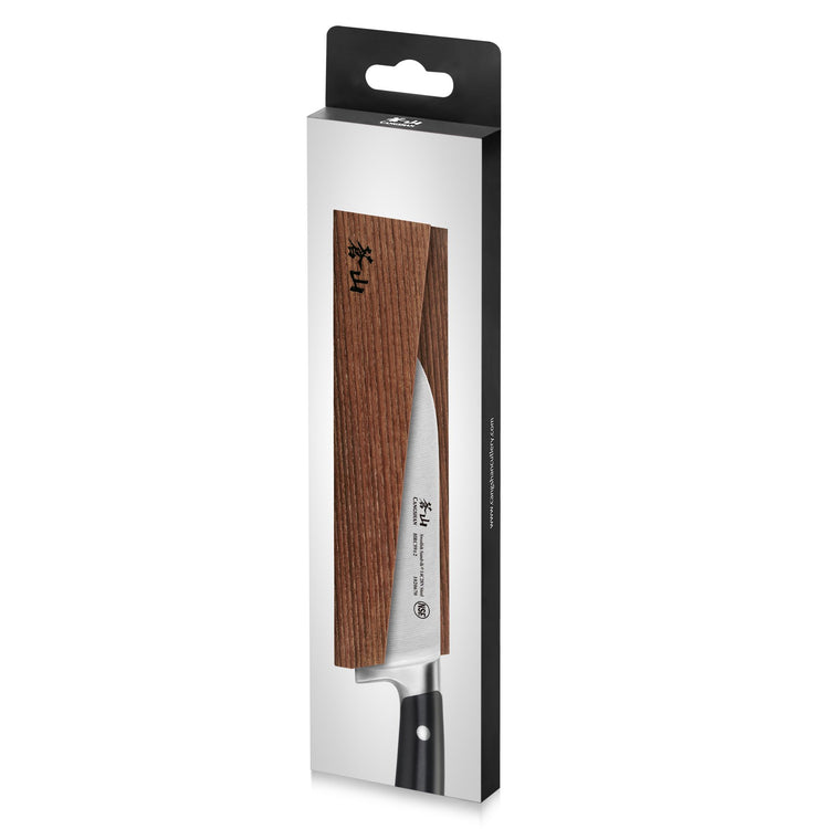 Magnetic knife sheath made of solid ash wood holding a kitchen knife with a black handle in retail packaging.