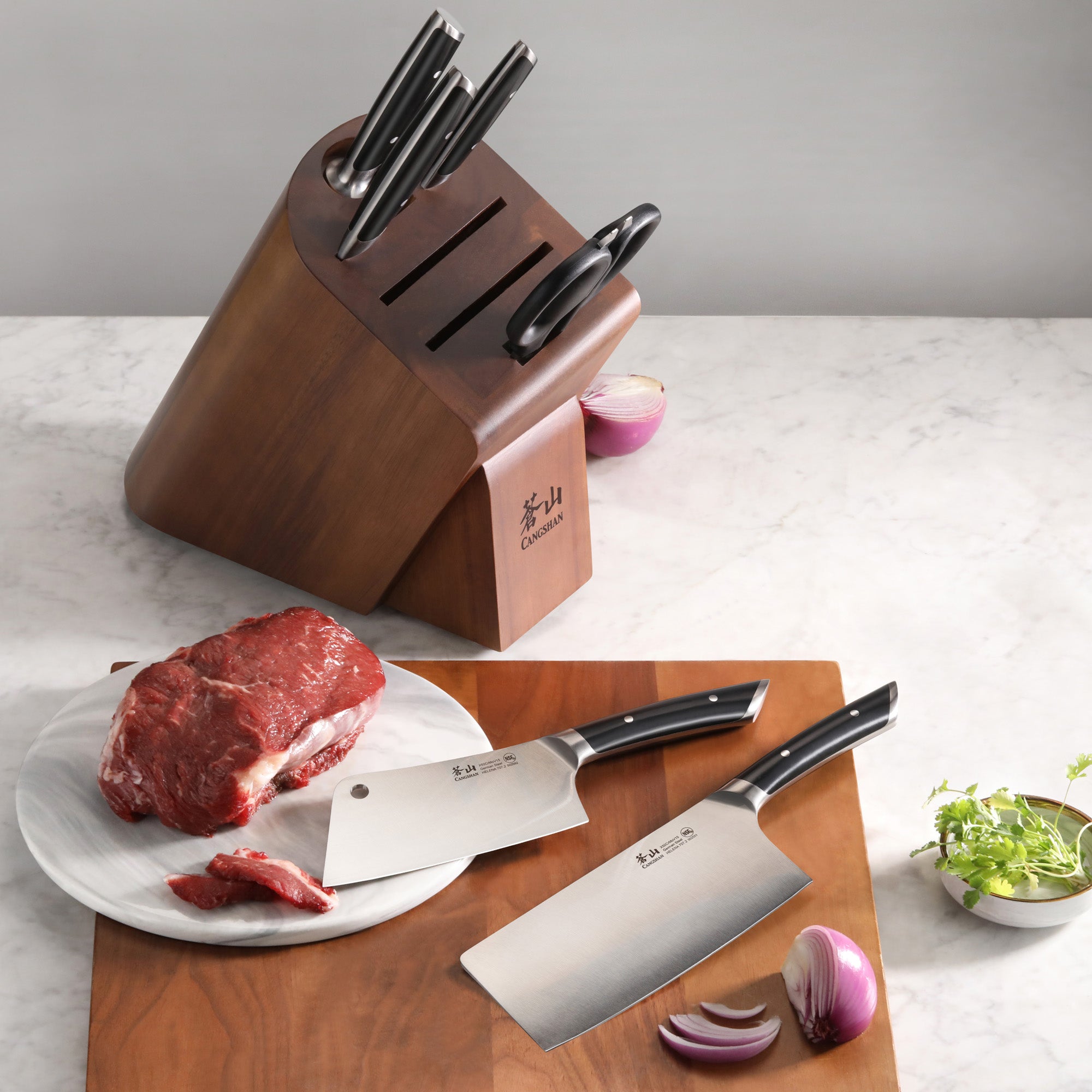 Knife block set with six knives in an acacia wood block, two cleaver knives on a cutting board with raw beef and onion.