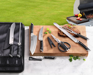 
                    
                      Nine-piece BBQ knife set with black handles, including knives, scissors, sharpening rod, and black carrying case on a cutting
                    
                  