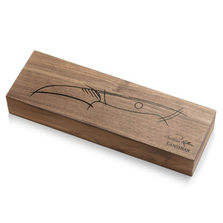 
                    
                      Rectangular wooden box with a line drawing of a peeling knife and a signature on the lid.
                    
                  