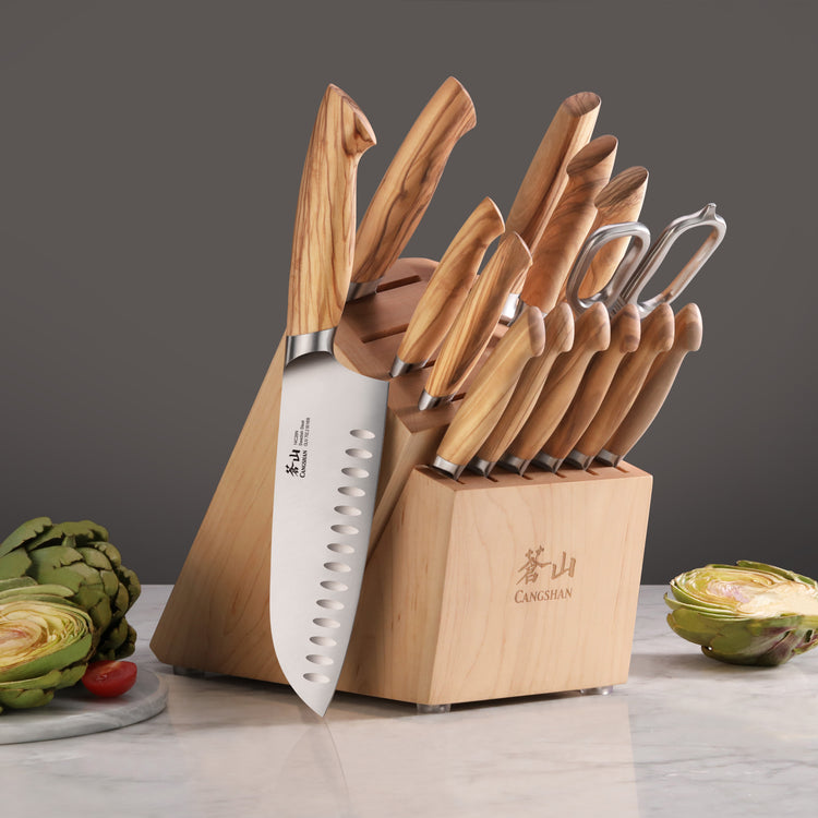 15-piece knife set with wooden handles in a wooden block, including kitchen shears, displayed on a marble surface.