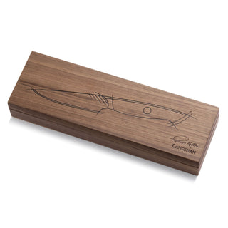 
                    
                      Rectangular wooden box with a knife sketch and signature on the lid, closed and resting on a white surface.
                    
                  