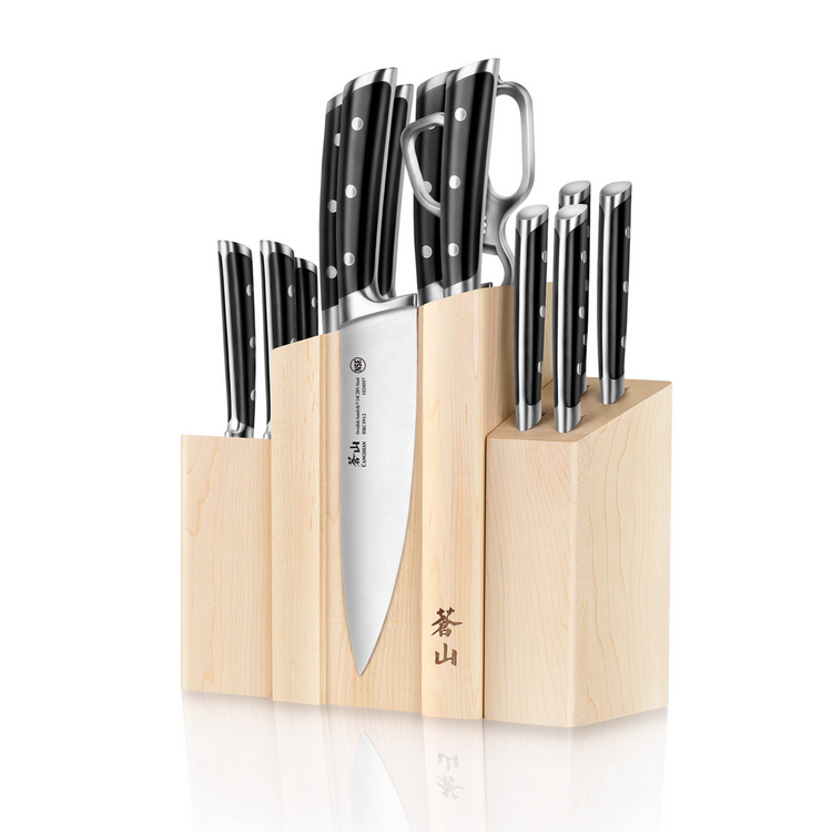 Wooden knife block set holding various knives with black handles and metal rivets, including a chef's knife and kitchen shear