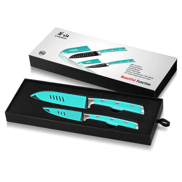 Two teal-handled kitchen knives in a black box with matching blade covers and product packaging.