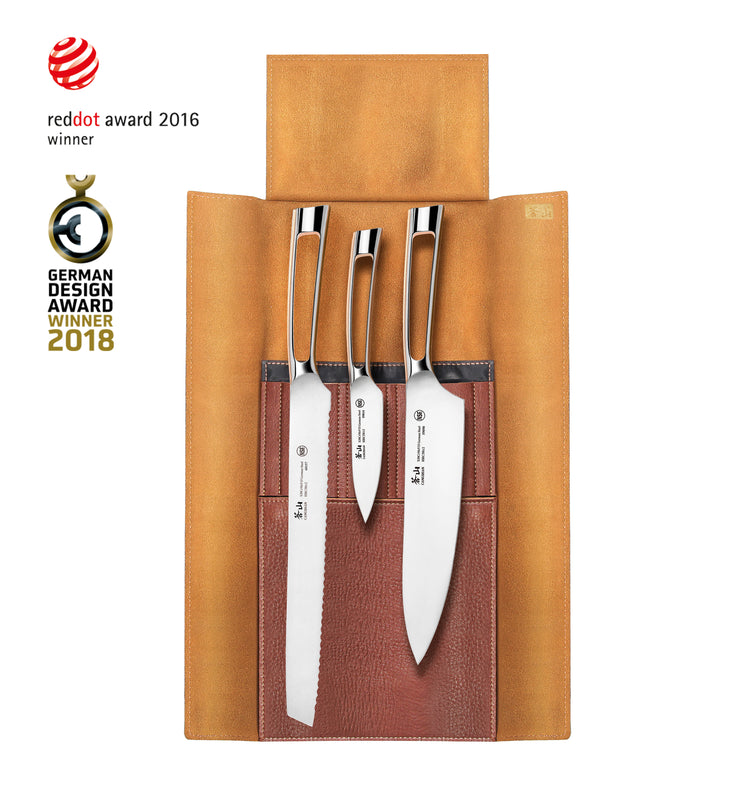 Four silver knives with black handles in a brown leather roll-up case, showing different blade shapes and sizes.