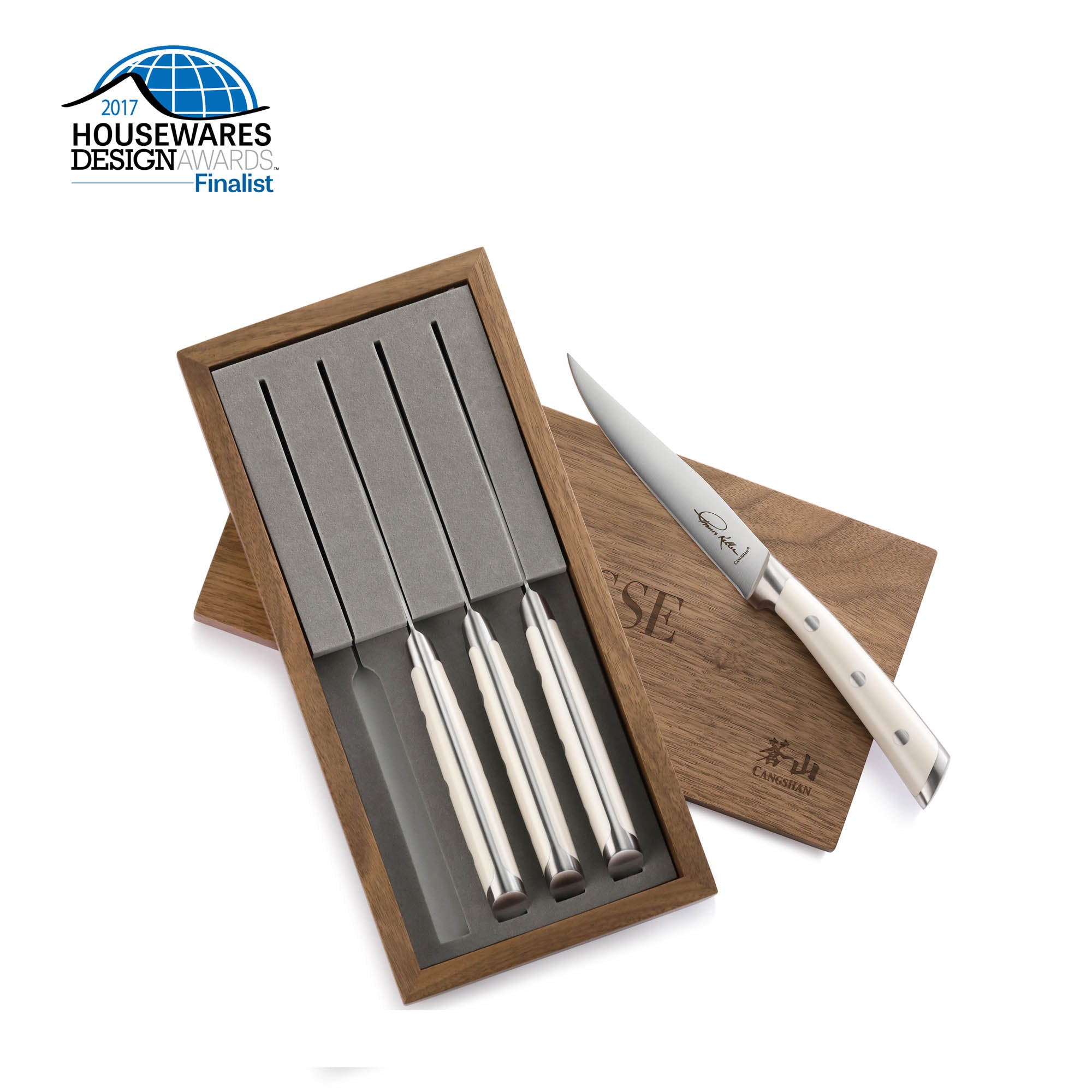Four straight edge steak knives with white handles in a walnut box, one knife displayed outside the box.